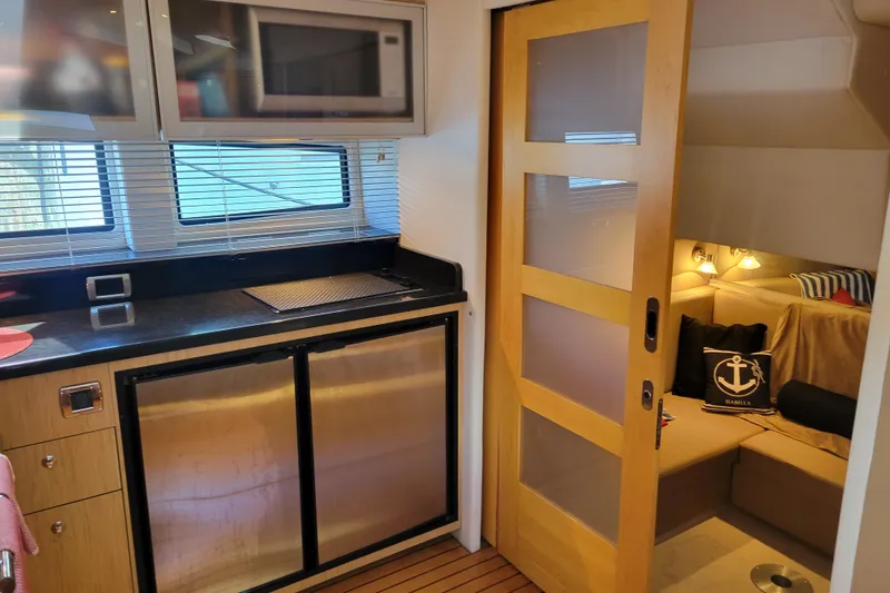 Slide: The Image of 2012 Four Winns V435 yacht interior with kitchenette and cozy seating area. - 67