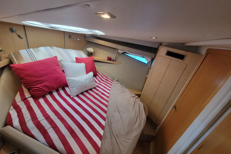 Slide: The Image of Cozy cabin interior of 2012 Four Winns V435 yacht with striped bedding and red pillows. - 73