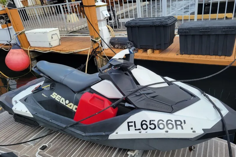 Slide: The Image of Jet ski docked beside a Four Winns V435, 2012 model, at a marina. - 76