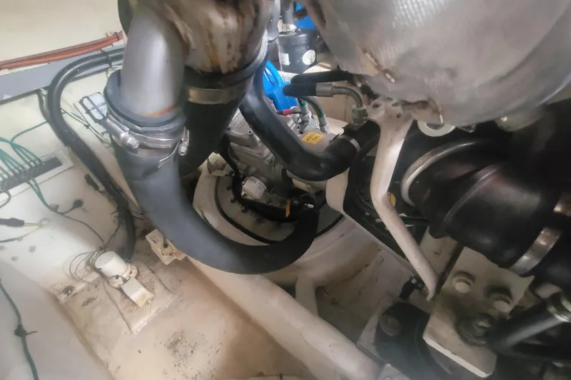 Slide: The Image of Engine compartment of a 2012 Four Winns V435 boat, showcasing hoses and mechanical components. - 81