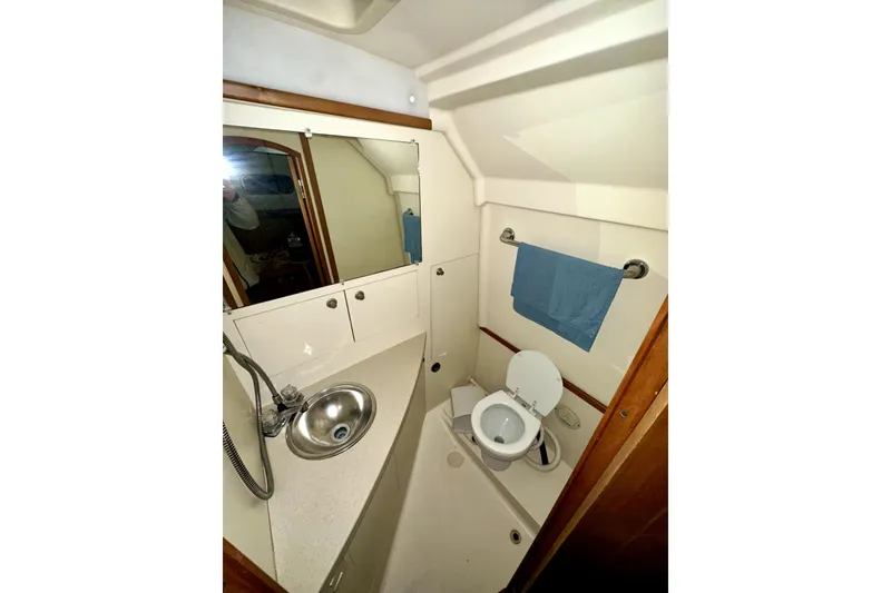 Slide: The Image of 2003 Mainship Pilot 30-II boat bathroom with sink, toilet, and mirror. - 10
