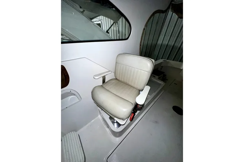 Slide: The Image of Captain's chair on 2003 Mainship Pilot 30-II boat, featuring white upholstery and armrests. - 6