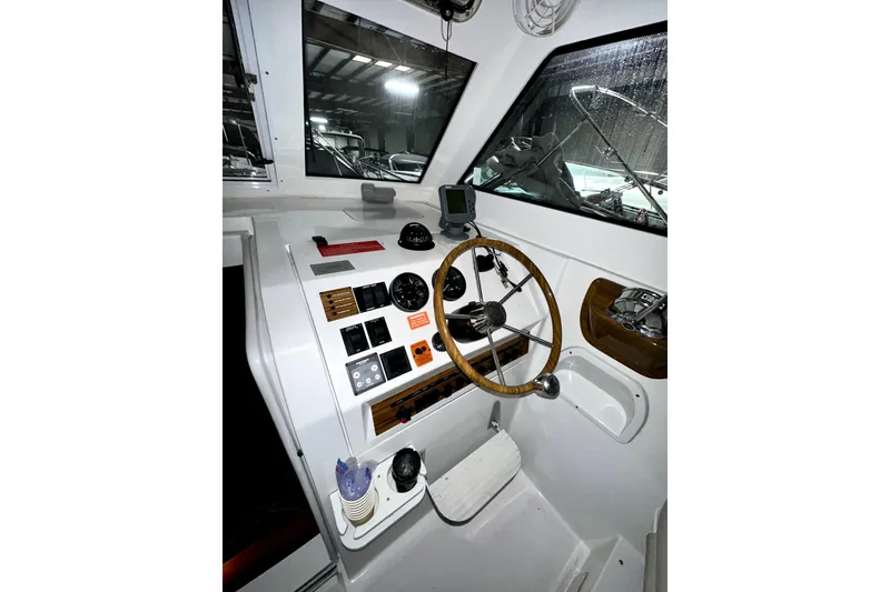 Slide: The Image of 2003 Mainship Pilot 30-II boat helm with steering wheel and control panel. - 7