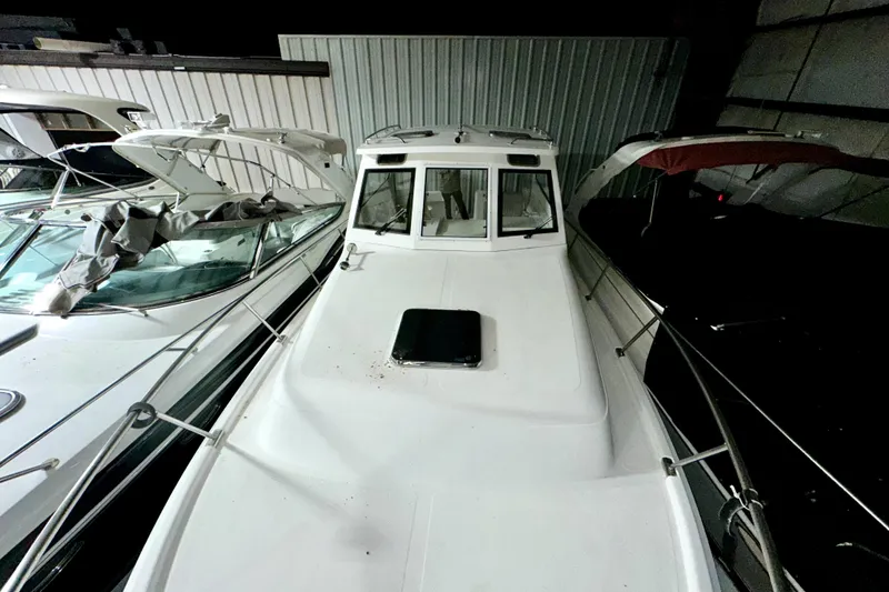 Slide: The Image of 2003 Mainship Pilot 30-II boat docked indoors, surrounded by other vessels. - 9
