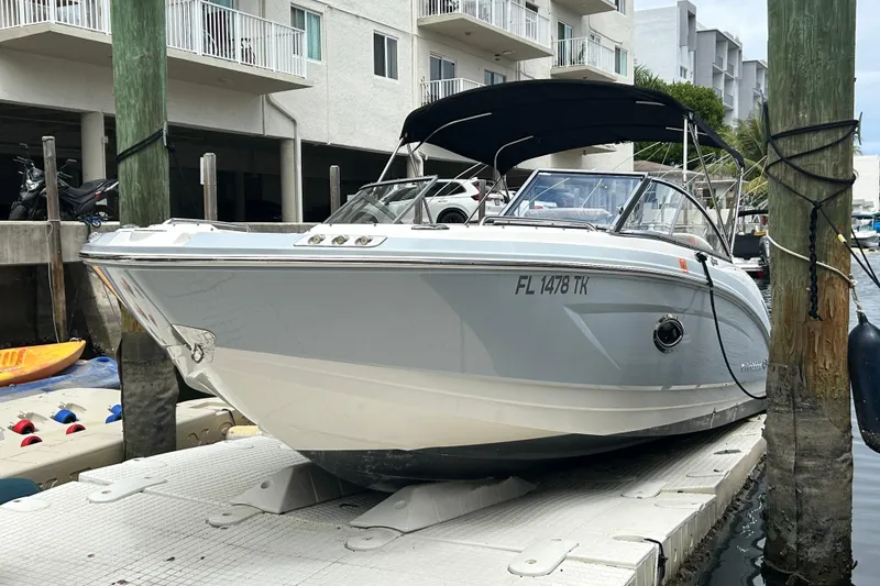 Slide: The Image of 2020 Chaparral 230 Suncoast boat docked at marina with black canopy. - 10