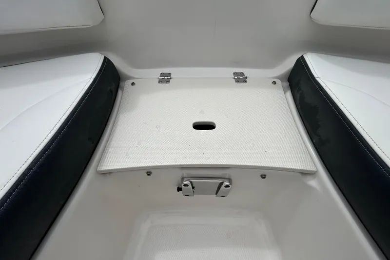Slide: The Image of 2020 Chaparral 230 Suncoast boat interior with seating and storage compartment. - 104