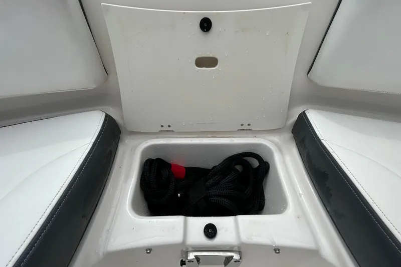 Slide: The Image of Storage compartment in 2020 Chaparral 230 Suncoast boat, featuring cup holders and speaker. - 105