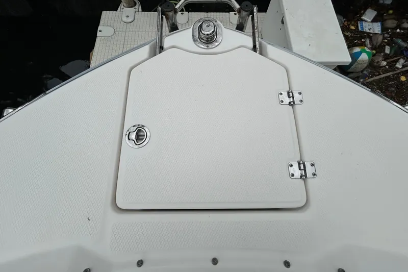 Slide: The Image of 2020 Chaparral 230 Suncoast boat interior storage compartment with cushioned seating. - 107