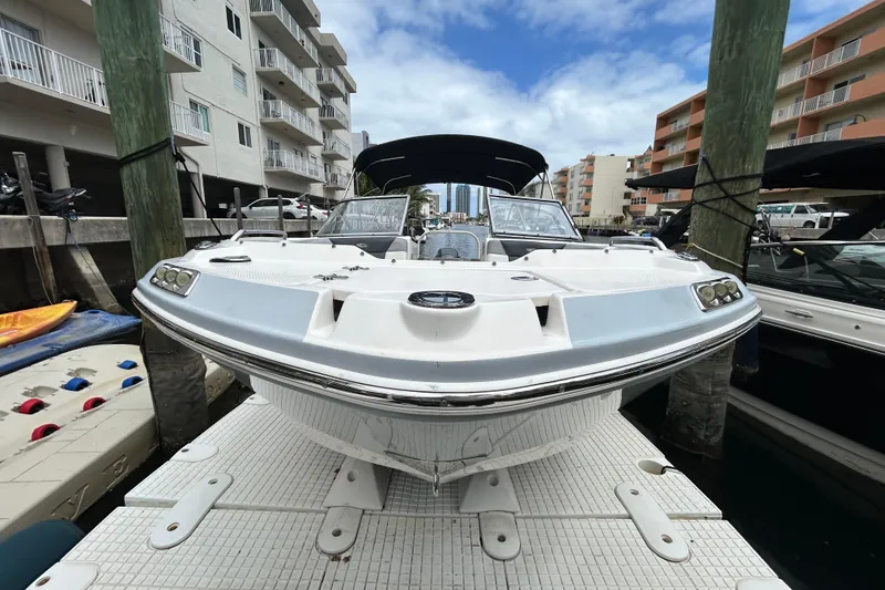 Slide: The Image of 2020 Chaparral 230 Suncoast boat docked at marina, surrounded by buildings. - 12