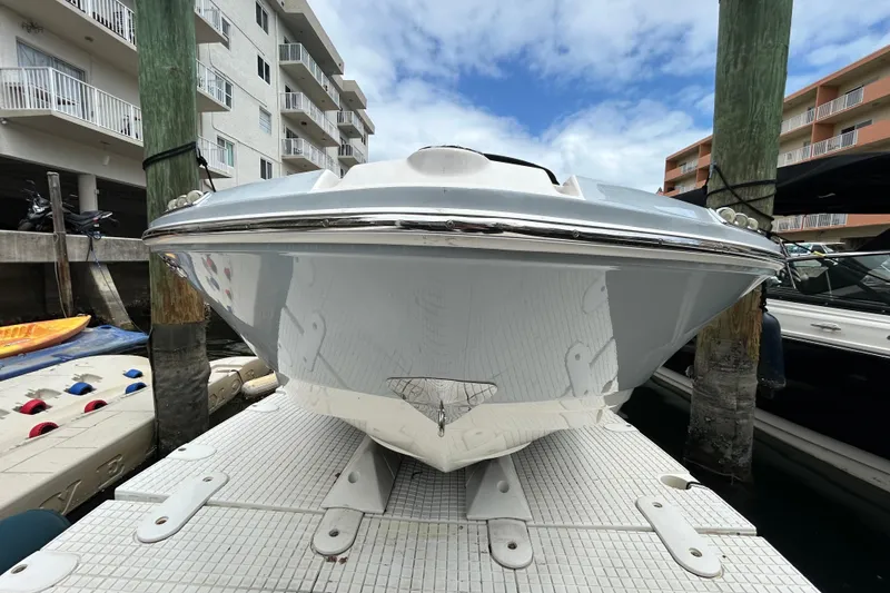 Slide: The Image of 2020 Chaparral 230 Suncoast boat docked, viewed from the front, with buildings in the background. - 13