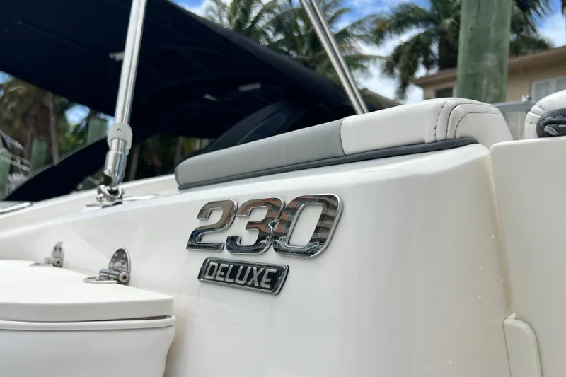 Slide: The Image of 2020 Chaparral 230 Suncoast boat with "230 Deluxe" emblem, featuring sleek design. - 17