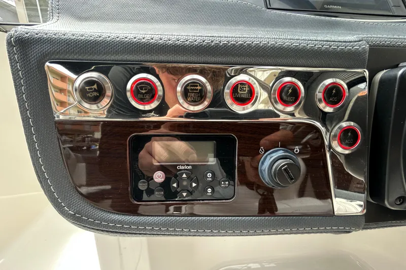 Slide: The Image of Control panel of 2020 Chaparral 230 Suncoast boat with various switches and Clarion audio system. - 27