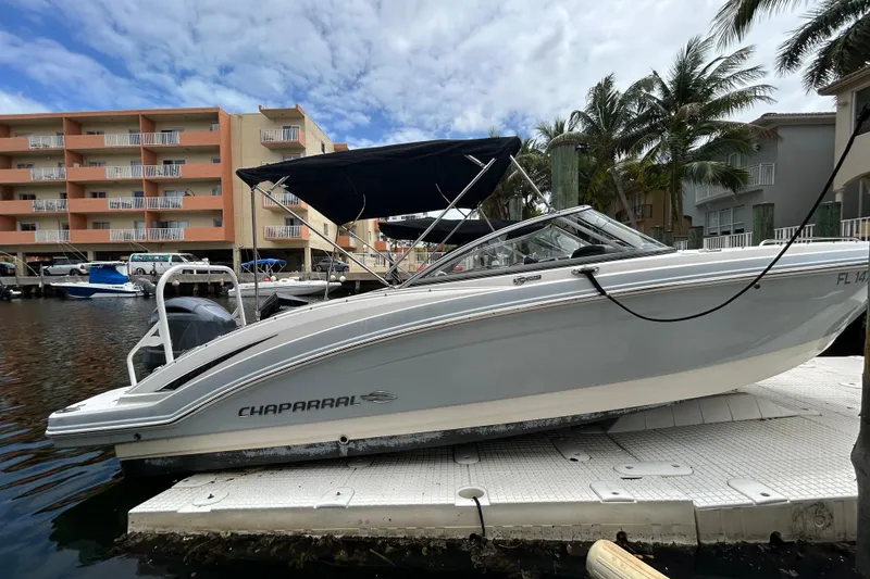 Slide: The Image of 2020 Chaparral 230 Suncoast boat docked near waterfront buildings and palm trees. - 3