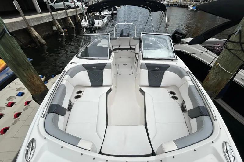 Slide: The Image of 2020 Chaparral 230 Suncoast boat with spacious seating, docked at a marina. - 38