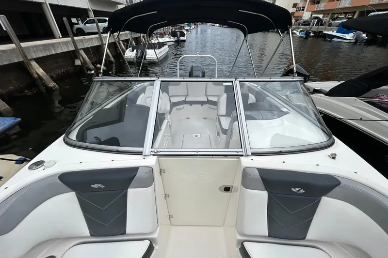 Slide: The Image of 2020 Chaparral 230 Suncoast boat with spacious seating, docked in a marina. - 41