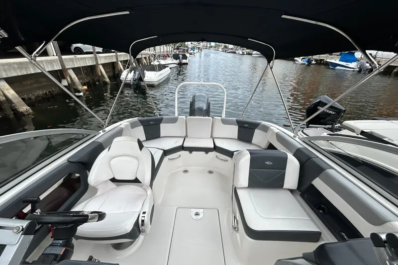 Slide: The Image of 2020 Chaparral 230 Suncoast boat interior with seating, docked in a marina. - 45