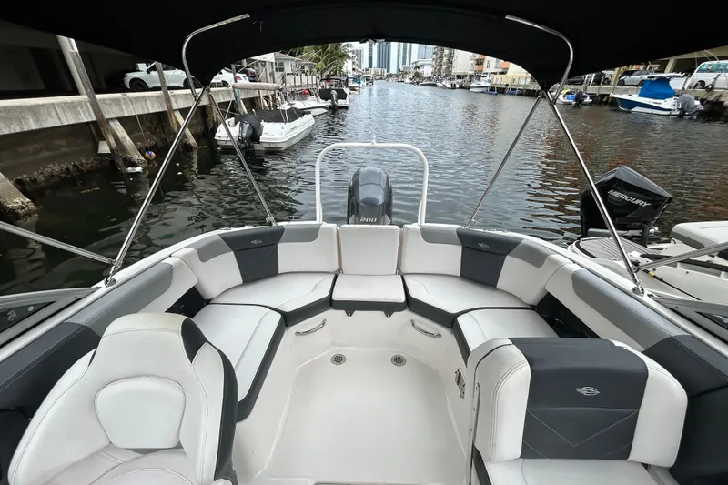 Slide: The Image of 2020 Chaparral 230 Suncoast boat interior with seating, docked in a canal. - 47