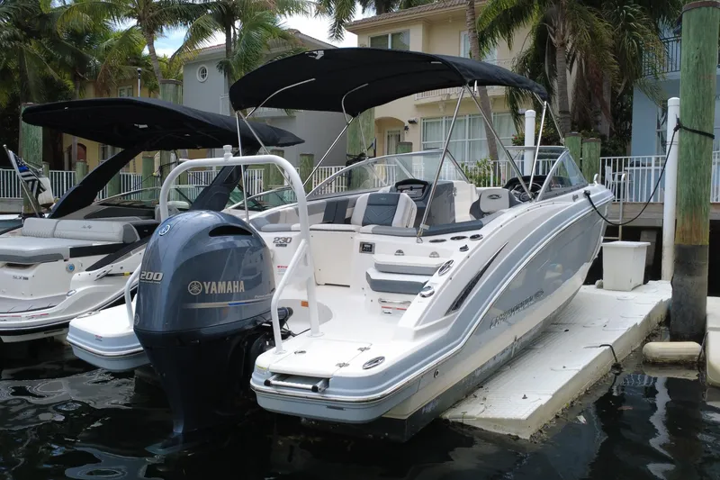 Slide: The Image of 2020 Chaparral 230 Suncoast boat docked with Yamaha engine, surrounded by palm trees. - 5