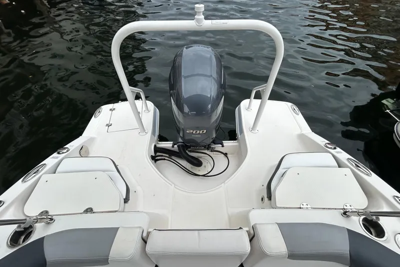 Slide: The Image of 2020 Chaparral 230 Suncoast boat with outboard motor, docked on calm water. - 50