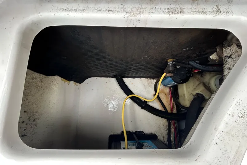 Slide: The Image of Storage compartment of a 2020 Chaparral 230 Suncoast boat, showing wiring and equipment. - 59