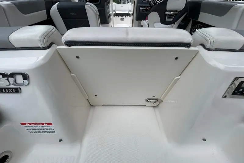 Slide: The Image of 2020 Chaparral 230 Suncoast boat interior, featuring seating and storage area. - 60
