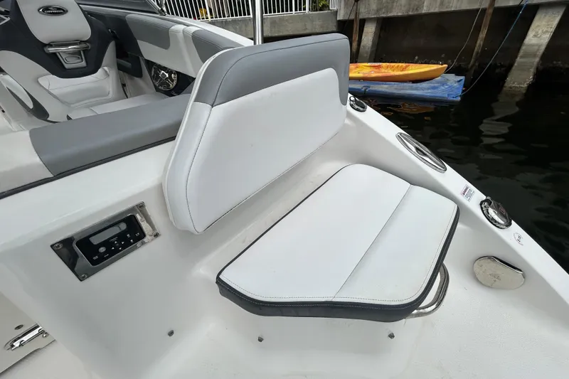 Slide: The Image of 2020 Chaparral 230 Suncoast boat interior with white seating and control panel. - 64