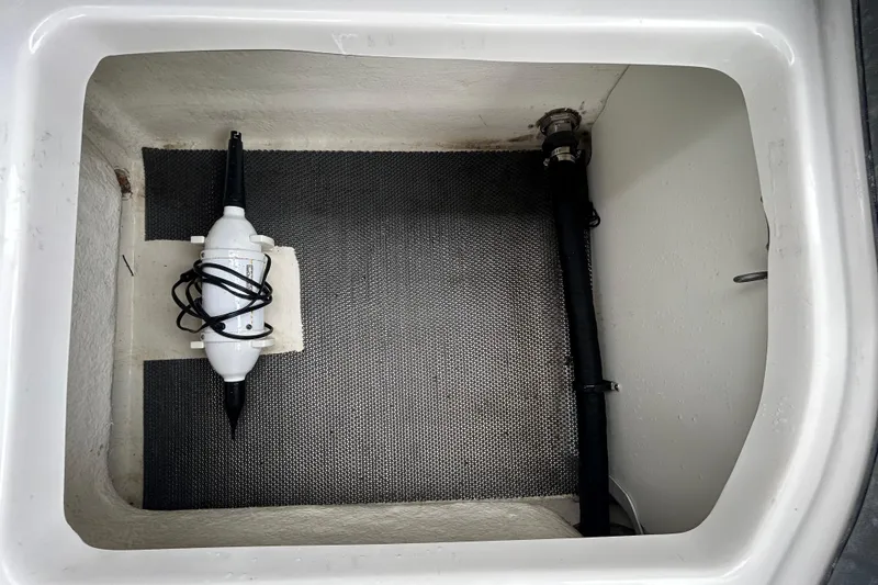 Slide: The Image of Storage compartment in a 2020 Chaparral 230 Suncoast boat, featuring a secured device. - 70