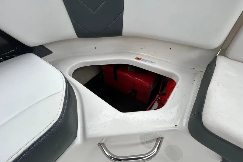 Slide: The Image of Storage compartment in 2020 Chaparral 230 Suncoast boat, featuring white and gray seating. - 72