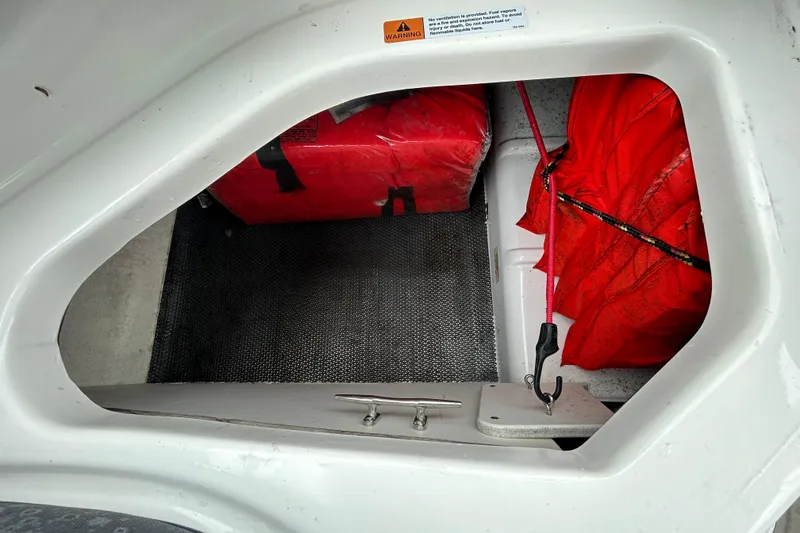 Slide: The Image of Storage compartment in 2020 Chaparral 230 Suncoast boat with red safety equipment. - 73