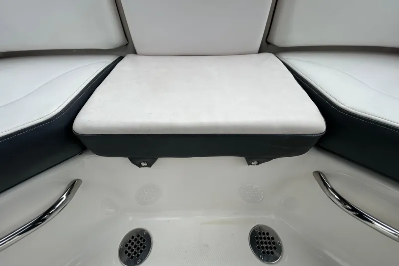 Slide: The Image of Interior seating of 2020 Chaparral 230 Suncoast boat with white cushions and metal handles. - 74