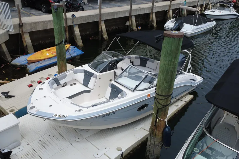 Slide: The Image of 2020 Chaparral 230 Suncoast boat docked at marina, featuring sleek design and spacious seating. - 8