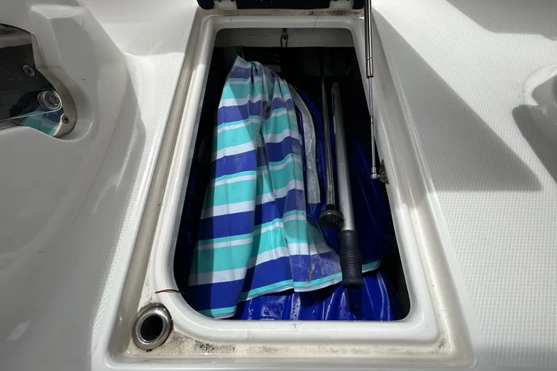 Slide: The Image of Storage compartment in 2020 Chaparral 230 Suncoast boat with striped fabric and equipment. - 84