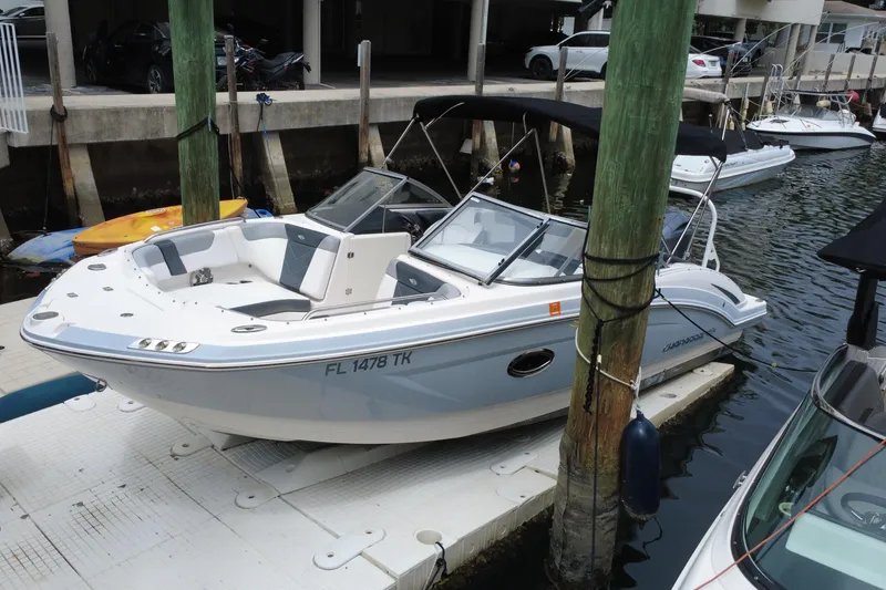 Slide: The Image of 2020 Chaparral 230 Suncoast boat docked at marina, featuring sleek design and spacious seating. - 9