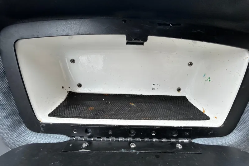 Slide: The Image of Storage compartment of a 2020 Chaparral 230 Suncoast boat, featuring a black interior mat. - 91