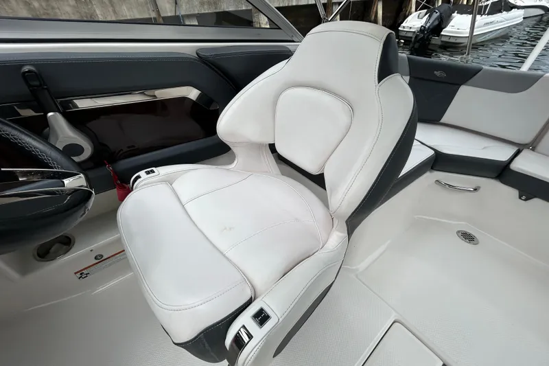 Slide: The Image of 2020 Chaparral 230 Suncoast boat interior with white captain's seat and sleek design. - 95