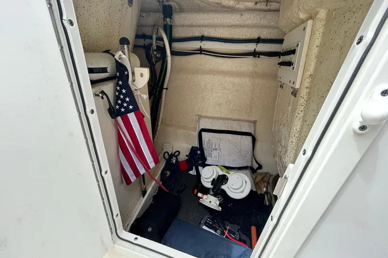 Slide: The Image of Interior storage of 2020 Chaparral 230 Suncoast boat with American flag and equipment. - 99