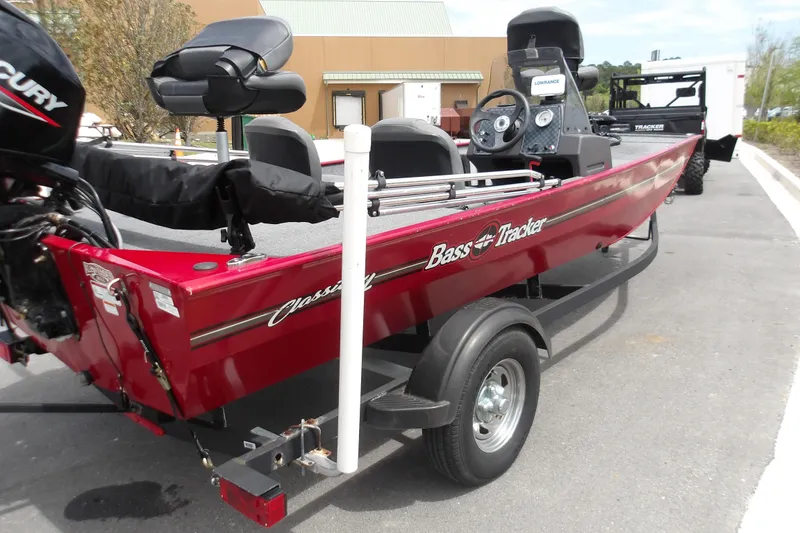 Slide: The Image of 2024 Tracker Bass Tracker Classic XL boat on trailer, red exterior, parked outdoors. - 7