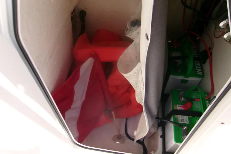 Slide: The Image of Storage compartment of 2020 Key West 203 FS boat with batteries and safety equipment. - 11