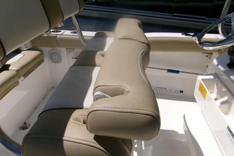 Slide: The Image of Interior seating of 2020 Key West 203 FS boat, featuring beige upholstery and stainless steel accents. - 7