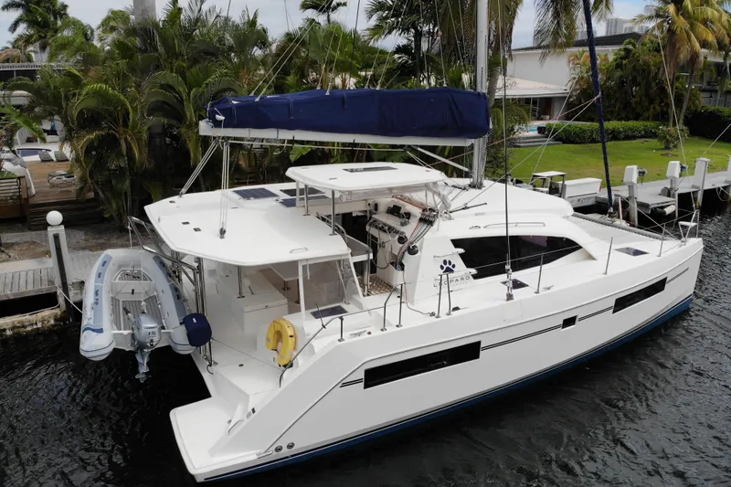 The Image of 2018 Leopard 40 catamaran docked by lush greenery and waterfront homes. - 0