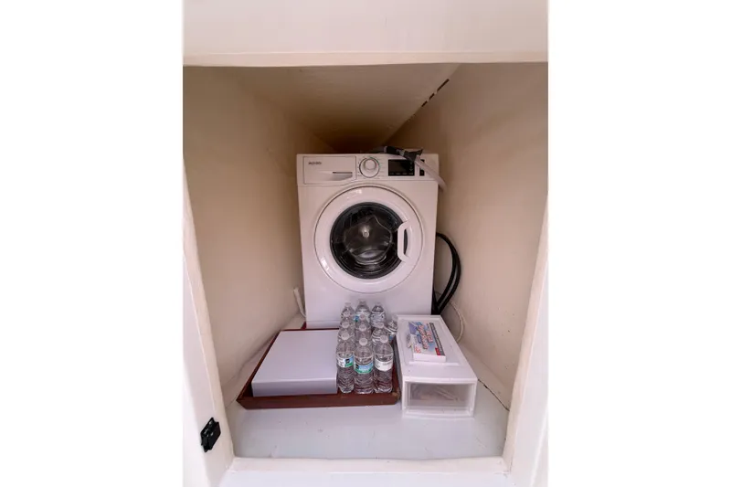 Slide: The Image of Compact laundry area with washing machine, water bottles, and storage on Leopard 40, 2018 model. - 37