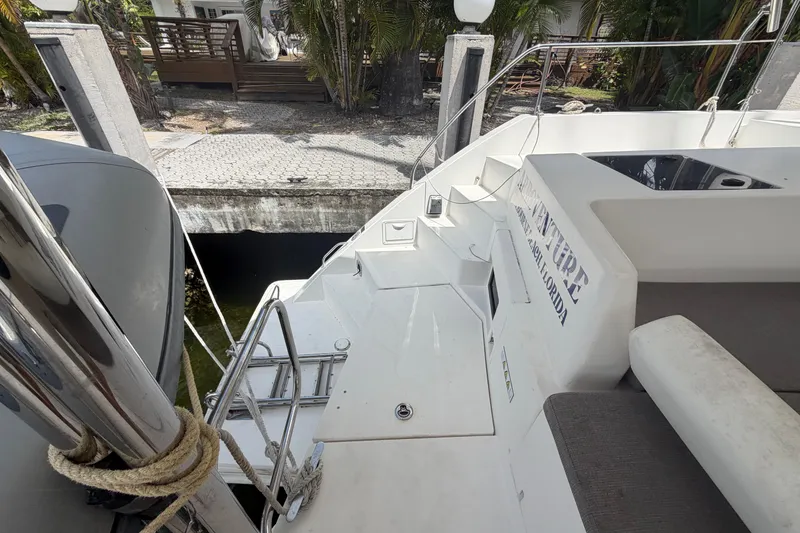 Slide: The Image of Leopard 40 catamaran docked, showing deck and seating area, surrounded by tropical foliage. - 46