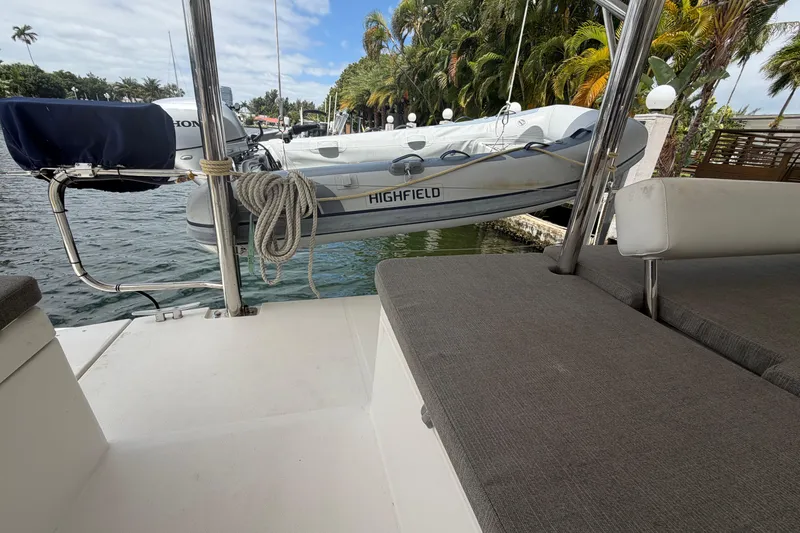 Slide: The Image of 2018 Leopard 40 yacht with a Highfield dinghy, docked near lush palm trees. - 49