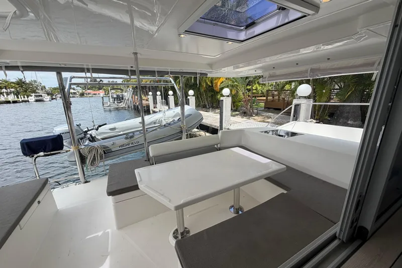 Slide: The Image of 2018 Leopard 40 catamaran interior with dining area, docked by a scenic waterfront. - 54