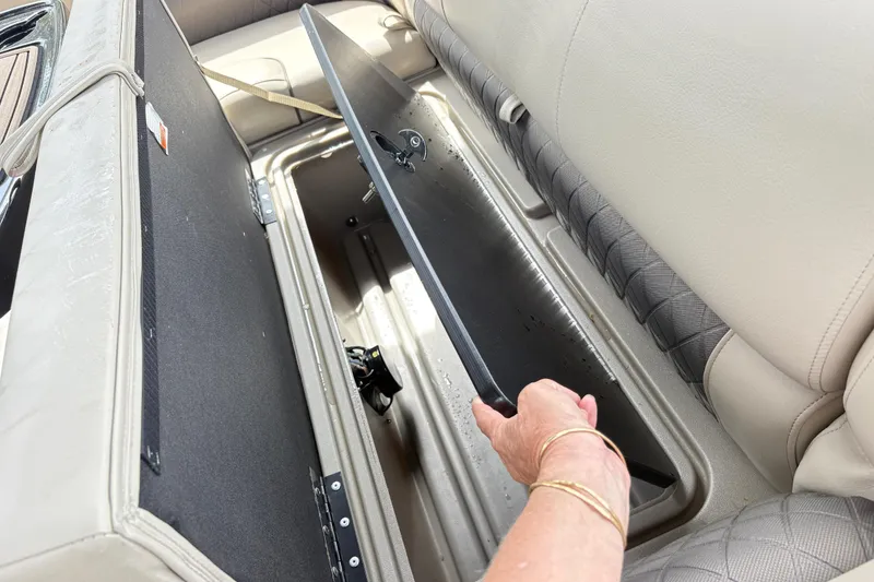 Slide: The Image of 2021 Sun Tracker Fishin' Barge 20 DLX storage compartment with open seat lid. - 11