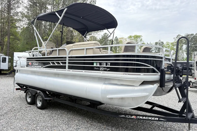Slide: The Image of 2021 Sun Tracker Fishin' Barge 20 DLX pontoon boat on trailer, parked outdoors. - 3