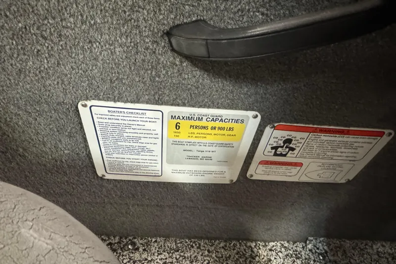 Slide: The Image of 2014 Tracker Targa V-18 WT capacity plate showing maximum capacity and safety warnings. - 8