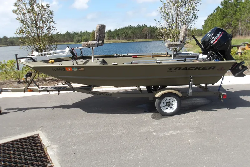 The Image of 2019 Tracker Grizzly 1448 Jon boat on trailer by a lake. - 0