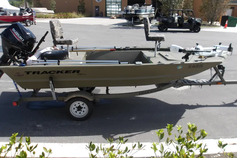 Slide: The Image of 2019 Tracker Grizzly 1448 Jon boat on trailer with Suzuki outboard motor. - 2