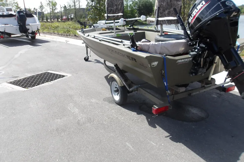 Slide: The Image of 2019 Tracker Grizzly 1448 Jon boat on trailer with Suzuki outboard motor. - 4